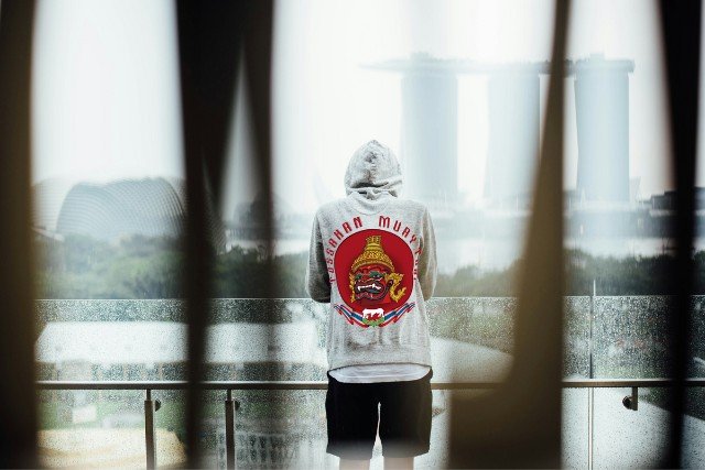 Man wearing hoodie with red logo.