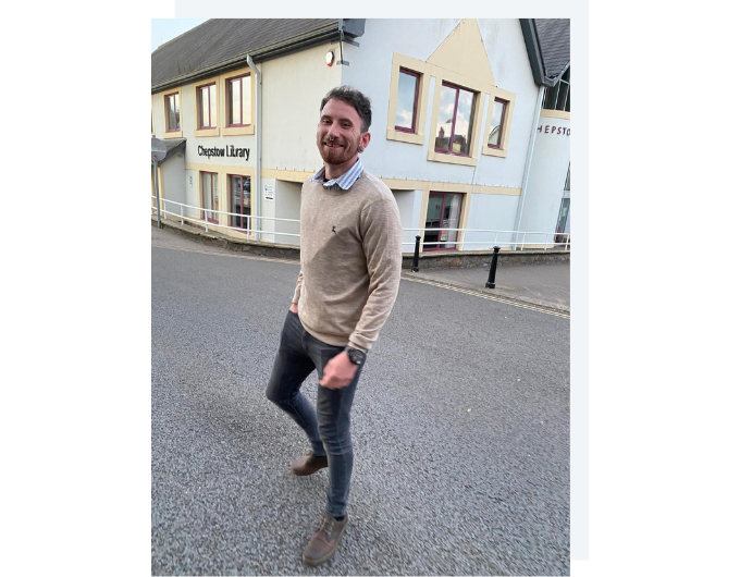 A smiling man walking on the street.